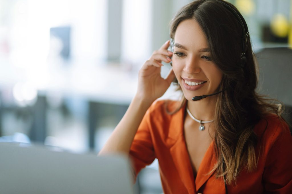 Young operator woman agent with headsets working in a call centre. Call center service.